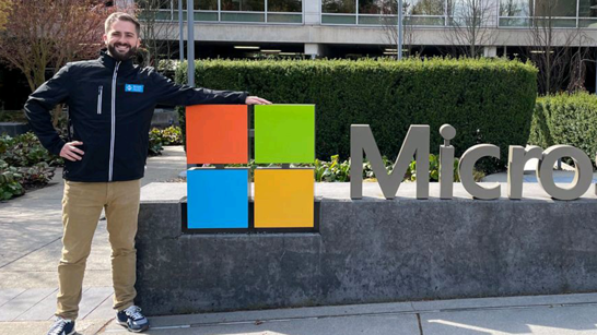 Man standing in front of the Microsoft Logo in Redmond