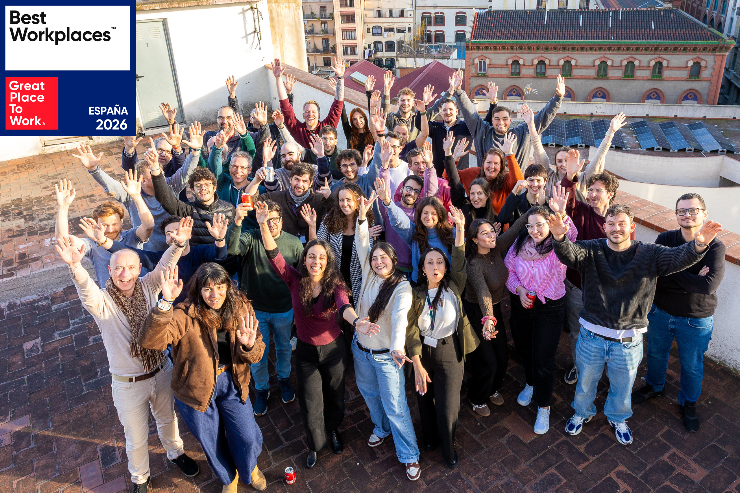 Large team group celebrating on rooftop with Best Workplaces Spain 2026 badge