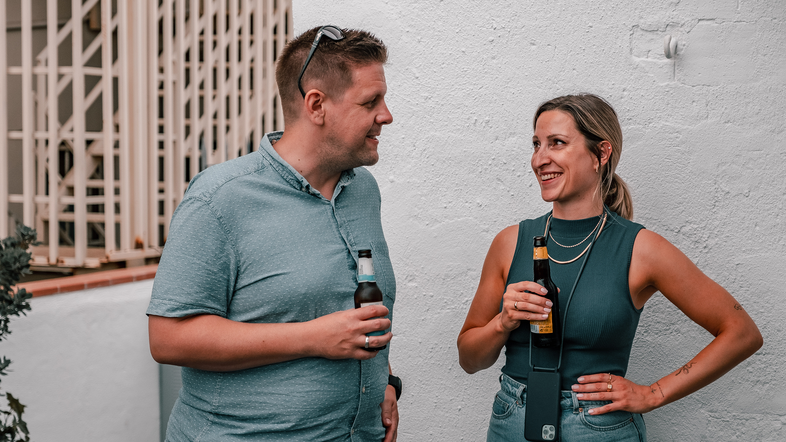 A man and a woman speaking while having a beer