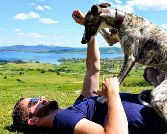 Ignacio Cepa lying in a green meadow with his dog