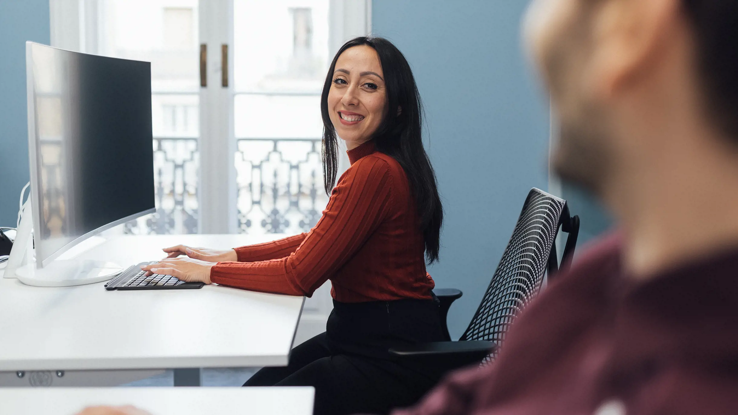 Woman in red top happily at work