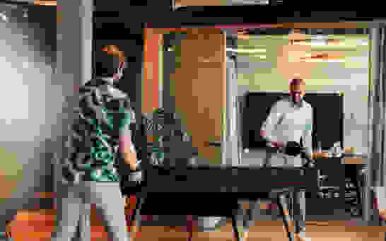 Home - Teamspirit Zwei Männer spielen in einem Büro Ping Pong