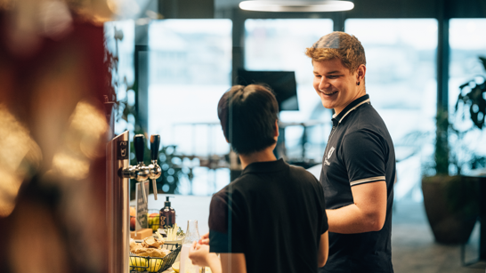 isolutions schnuppern Zwei Lehrlinge vor dem Wasser-Zapfhahnen in einem Büro