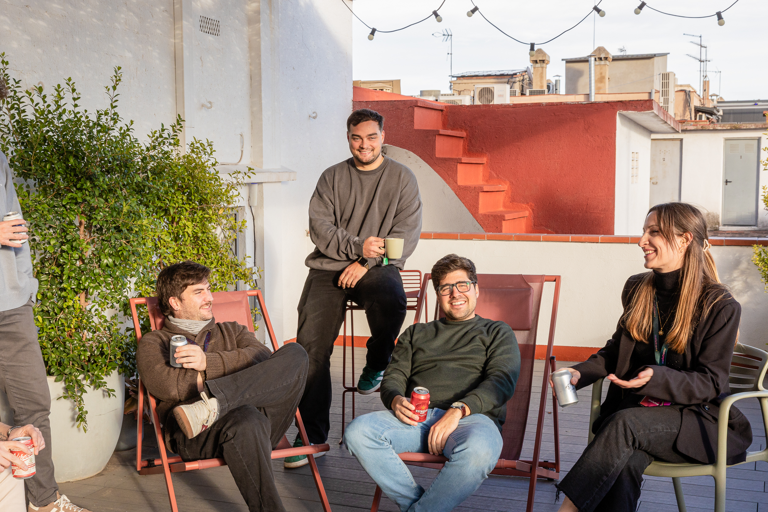 Team relaxing with drinks on rooftop terrace at office social event