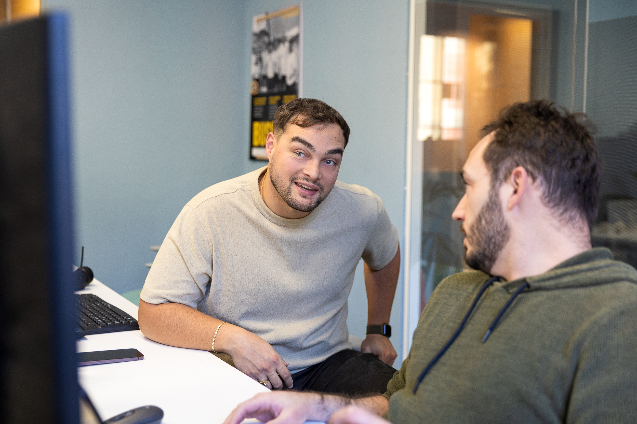 Two coworkers chatting at the desk