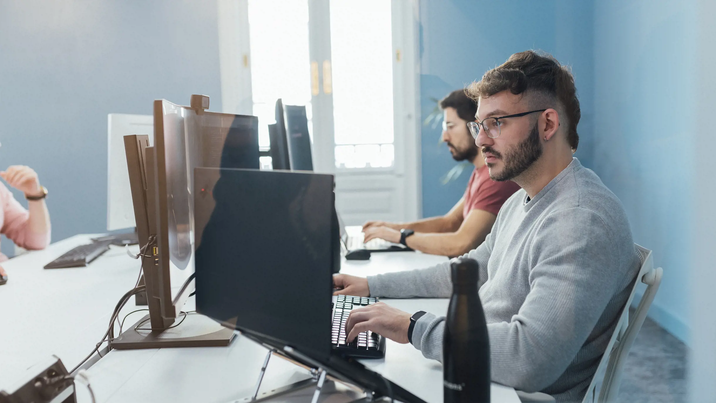 Man concentrated on working with two screens in modern office