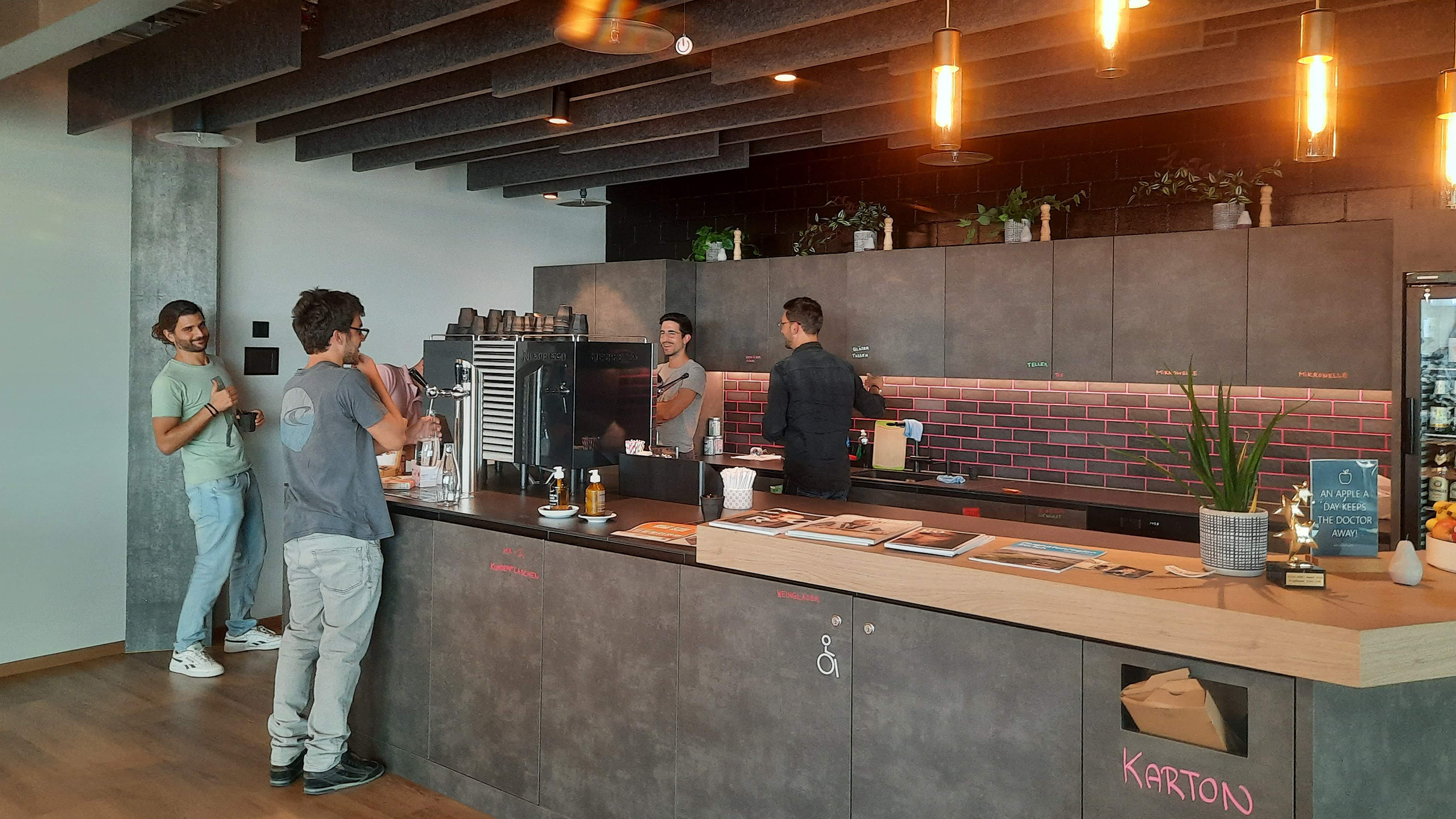 Employees in the office kitchen having a coffee