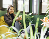 Team - Flat hierarchies Woman sitting on a yellow chair smiling