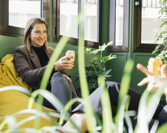 Team - Flat hierarchies Woman sitting on a yellow chair smiling