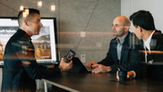 Offene Stelle bei isolutions als System Engineer M365 Cloud Workplace Männlicher System Engineer diskutiert mit zwei anderen Männern in Sitzungszimmer