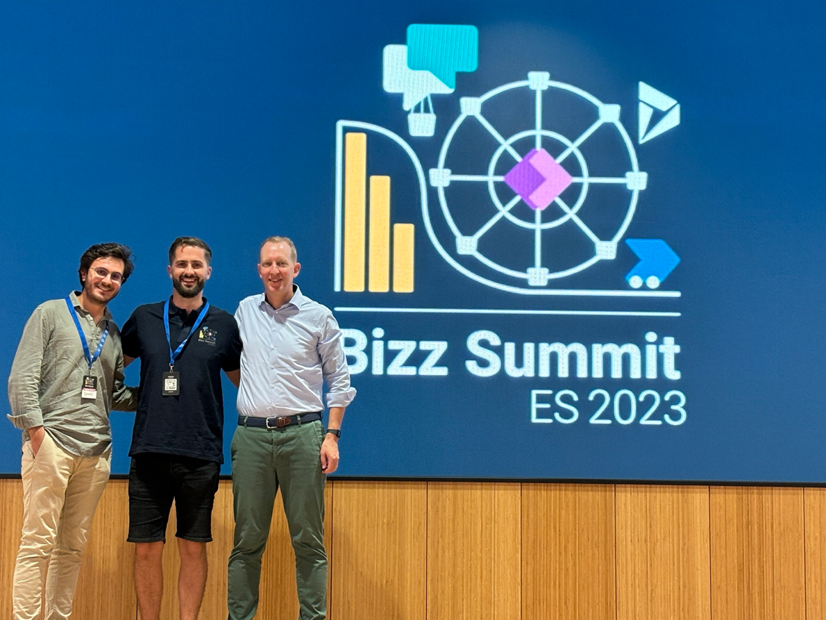 Three men standing on a stage in front of the Bizz Summit Logo 2023