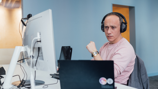 Azure Engineer Engineer in pink pullover concentrated on working with two screens