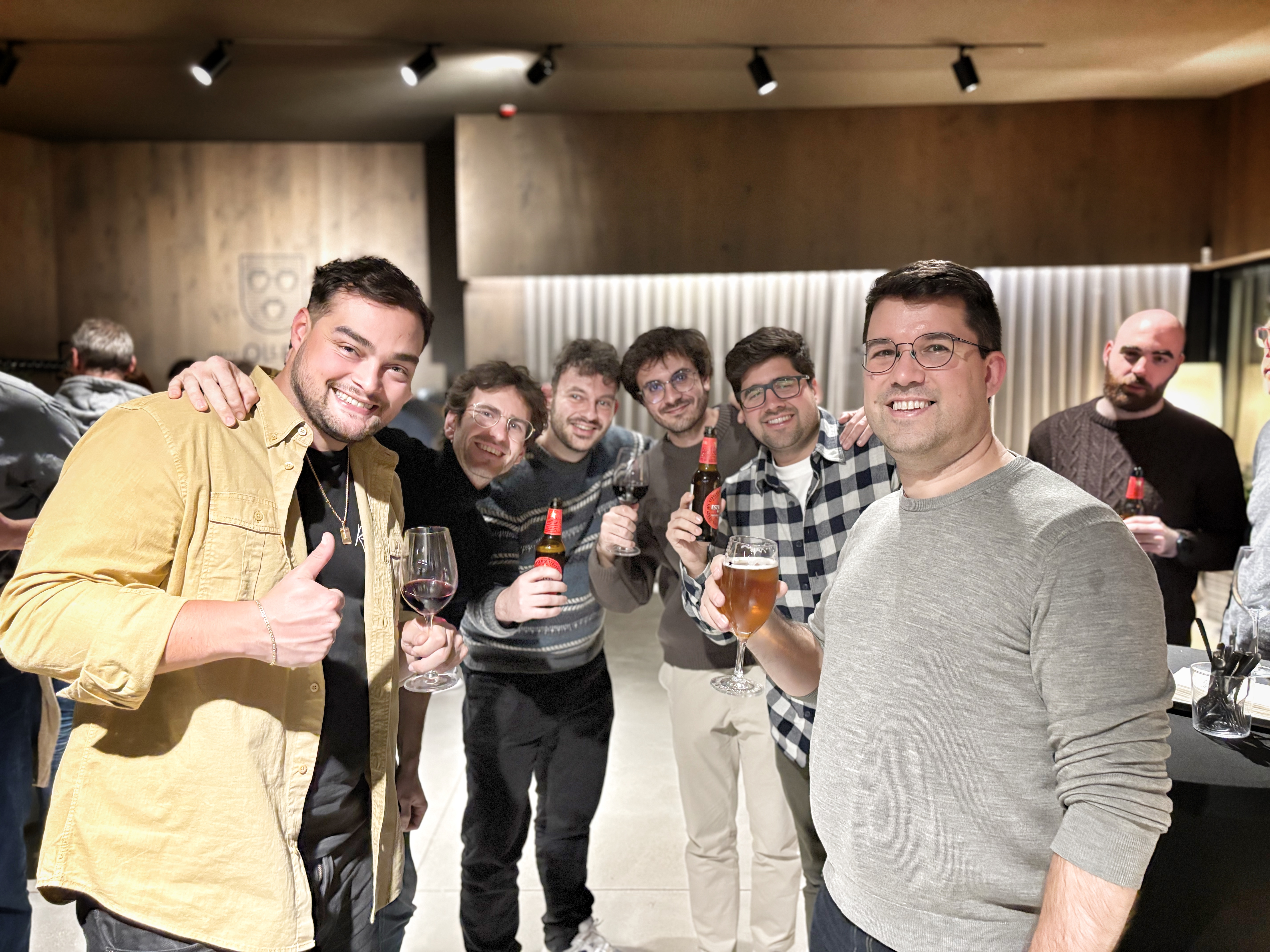 Team holding drinks at company social event indoors