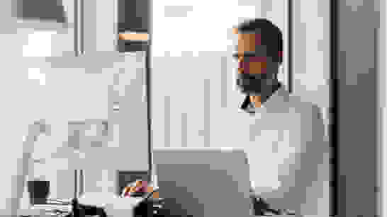 Data Security Mann vor Laptop und Bildschirm prüft isolutions Services zu Data Security