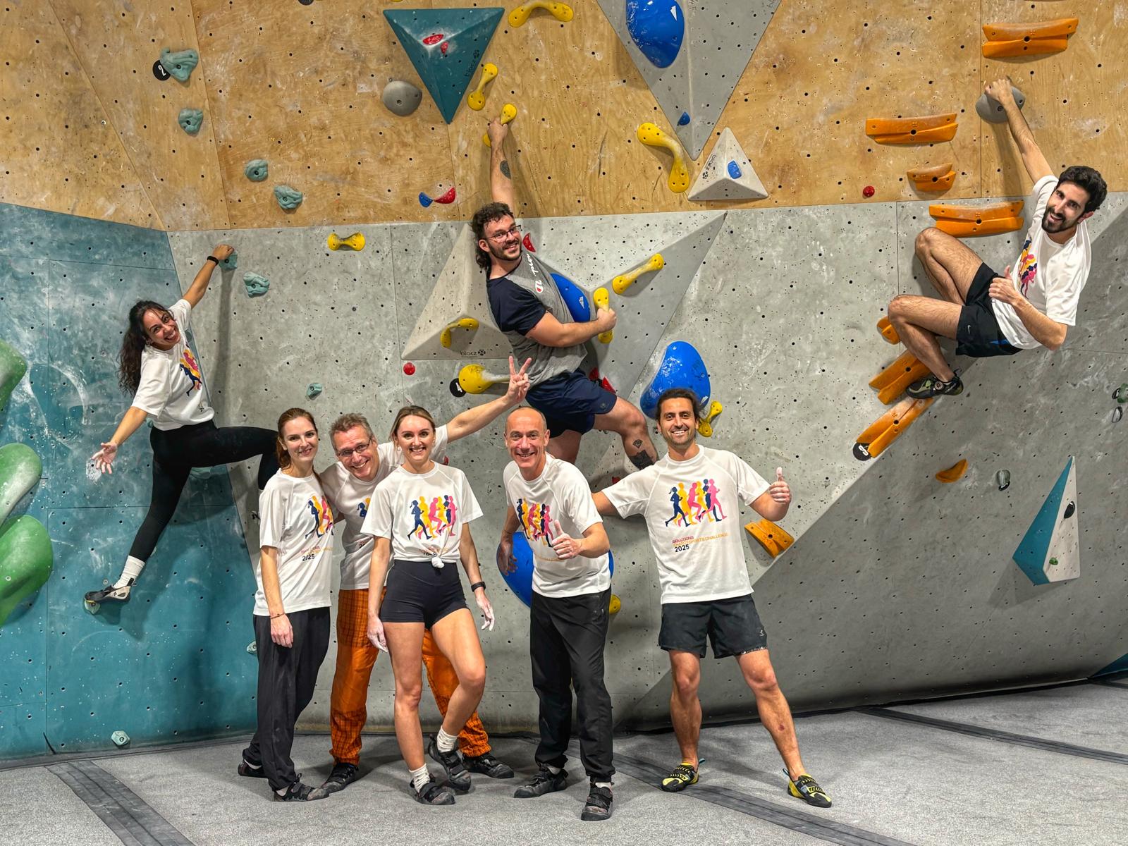 Group climbing indoor bouldering wall during team activity