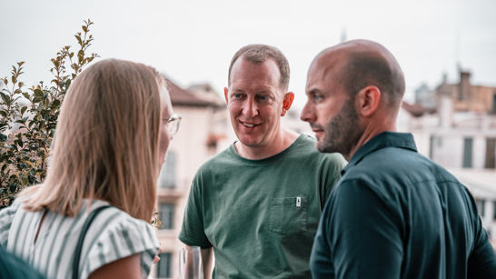 BeachBootCamp 2022 Leadership Networking A woman and two men having a conversation outdoors during summer