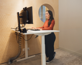 Woman working on a standing desk with a PC