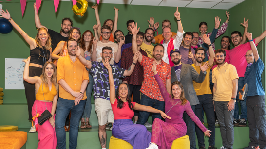 5 years isolutions Barcelona Group of people dressed in pink, purple and orange