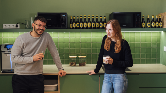 Office Life - Coffee Break Employees having a coffee standing in a green kitchen