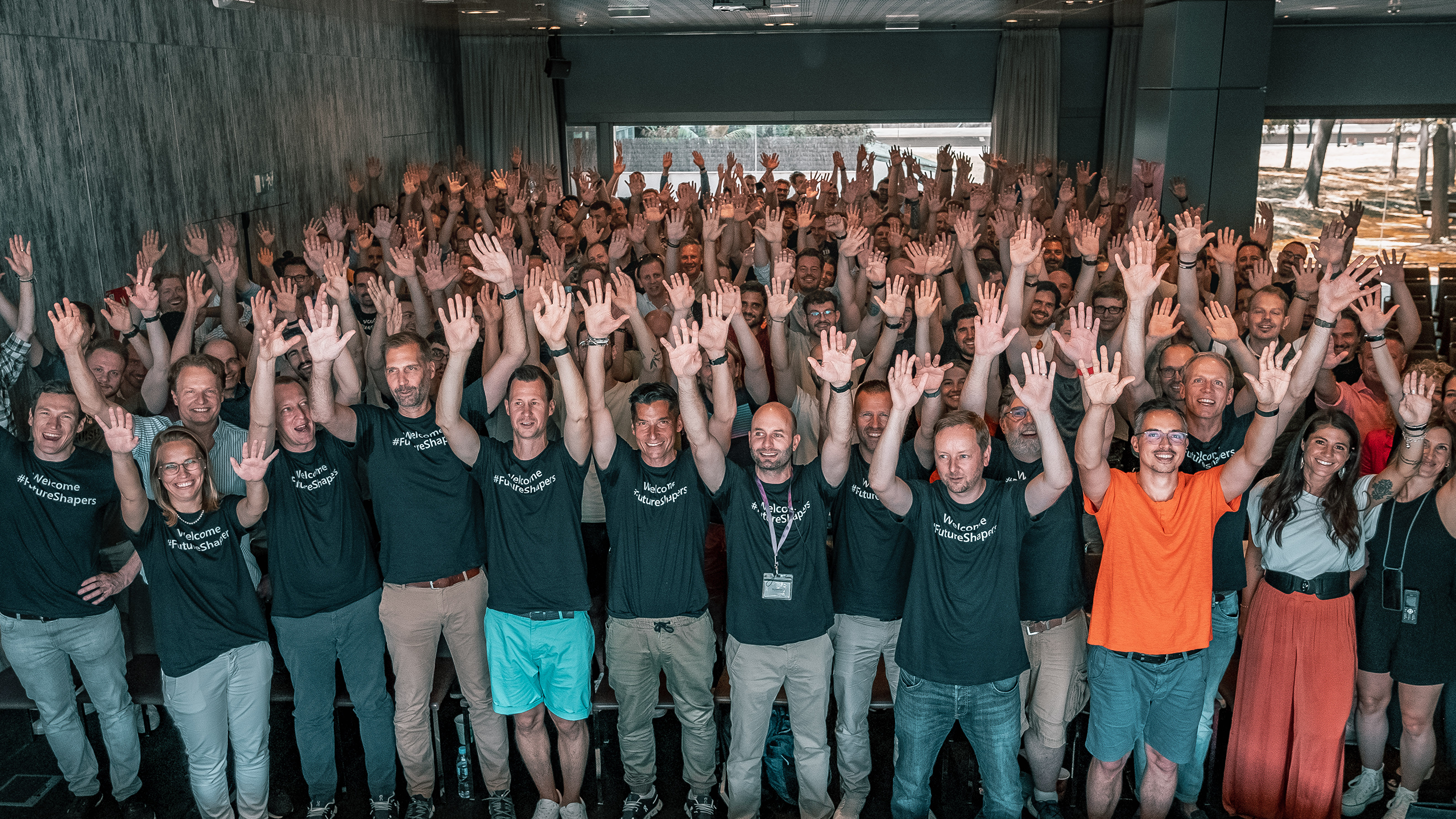 Group of people standing with hands in the air