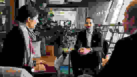 Business Solutions 3 Personen in Lounge besprechen das isolutions Angebot zu Business Solutions