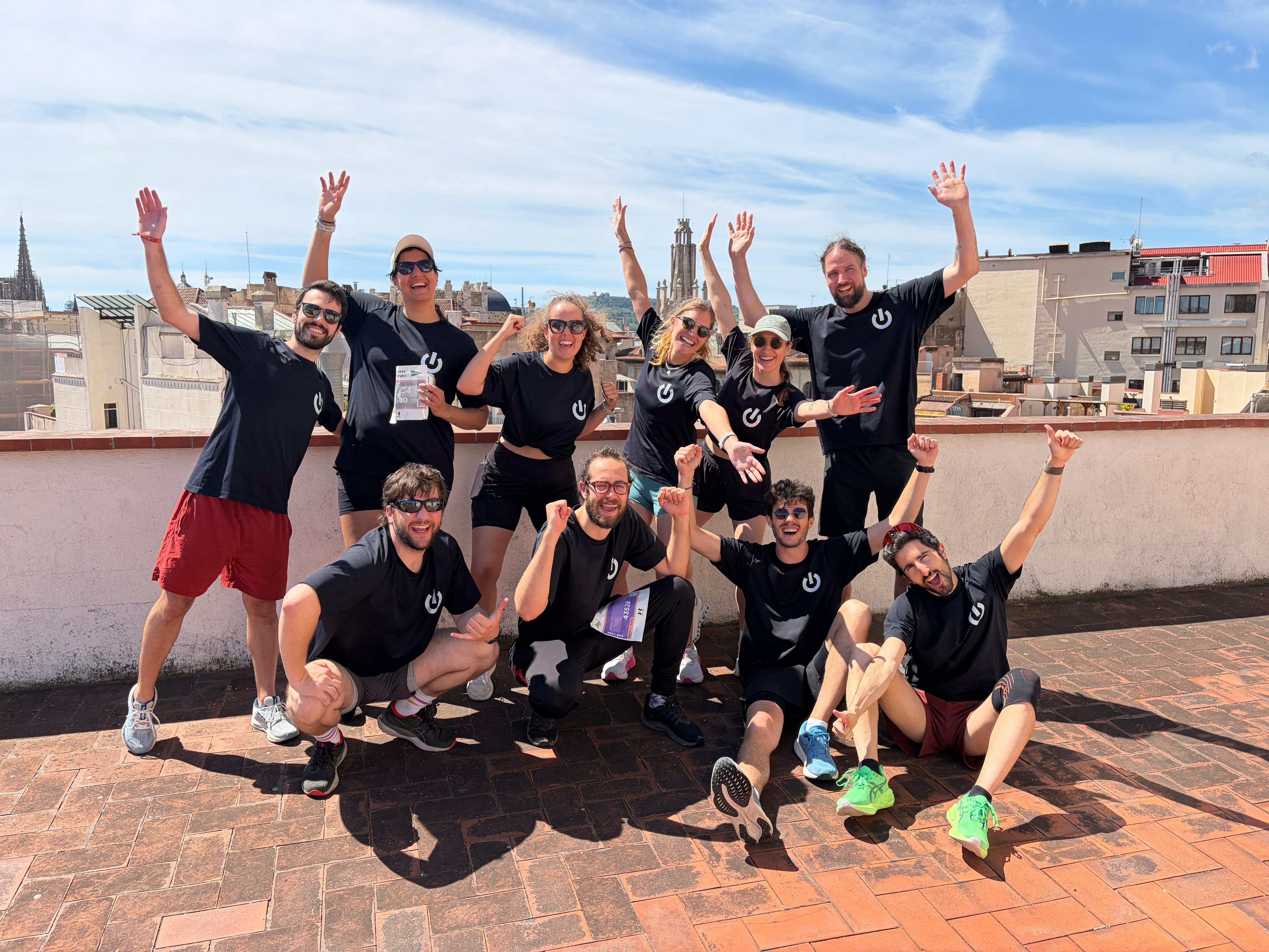 Team in sporty outfits celebrating on rooftop terrace with city skyline view