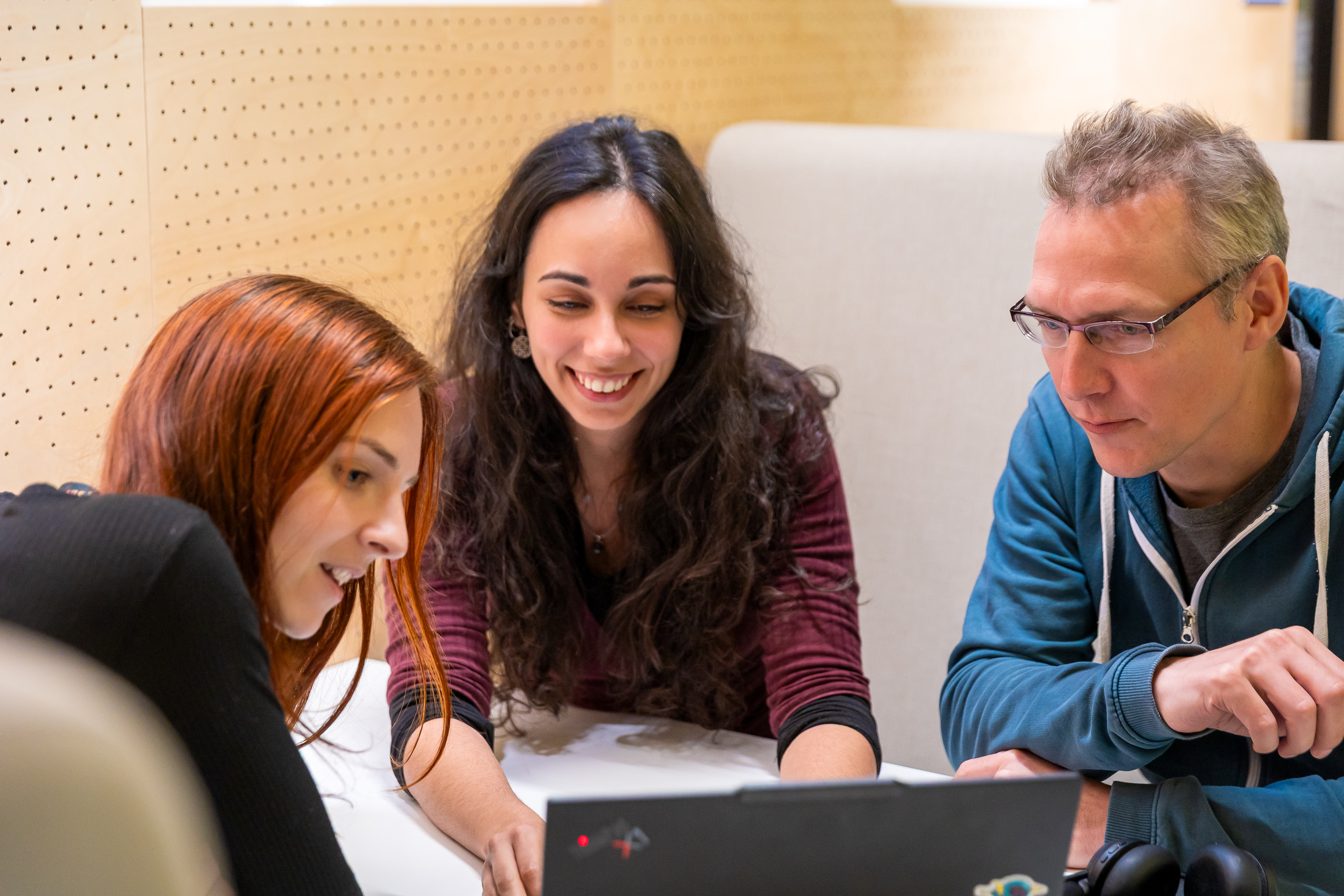 Team collaborating around laptop in meeting room