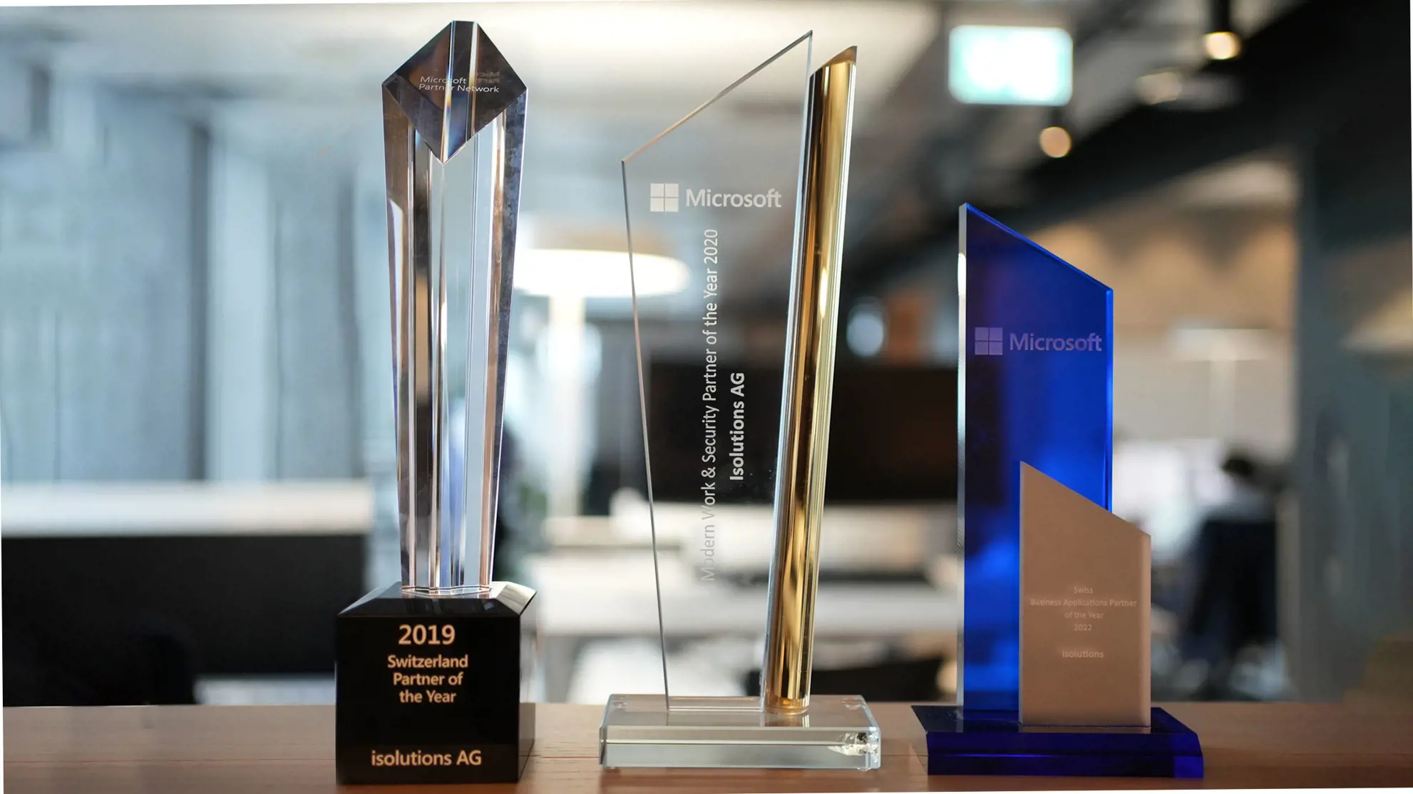Drei Microsoft Award Pokale nebeneinander aufgereiht