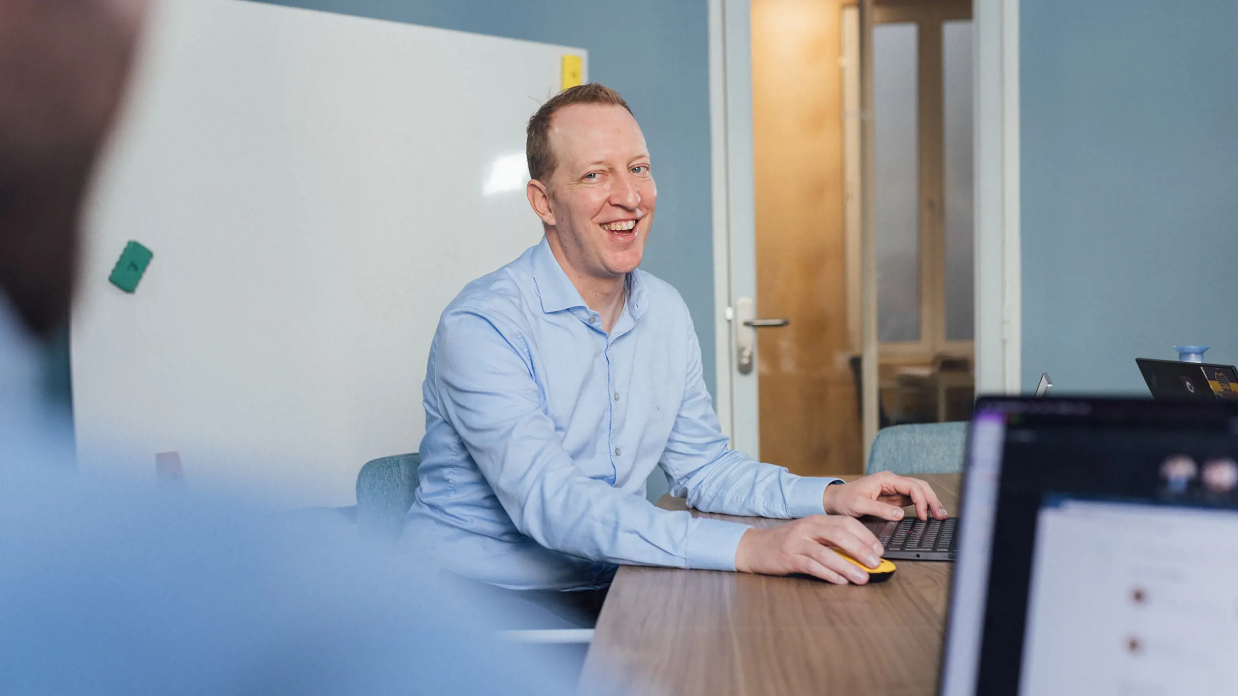 Man sitting on a meeting room table smiling