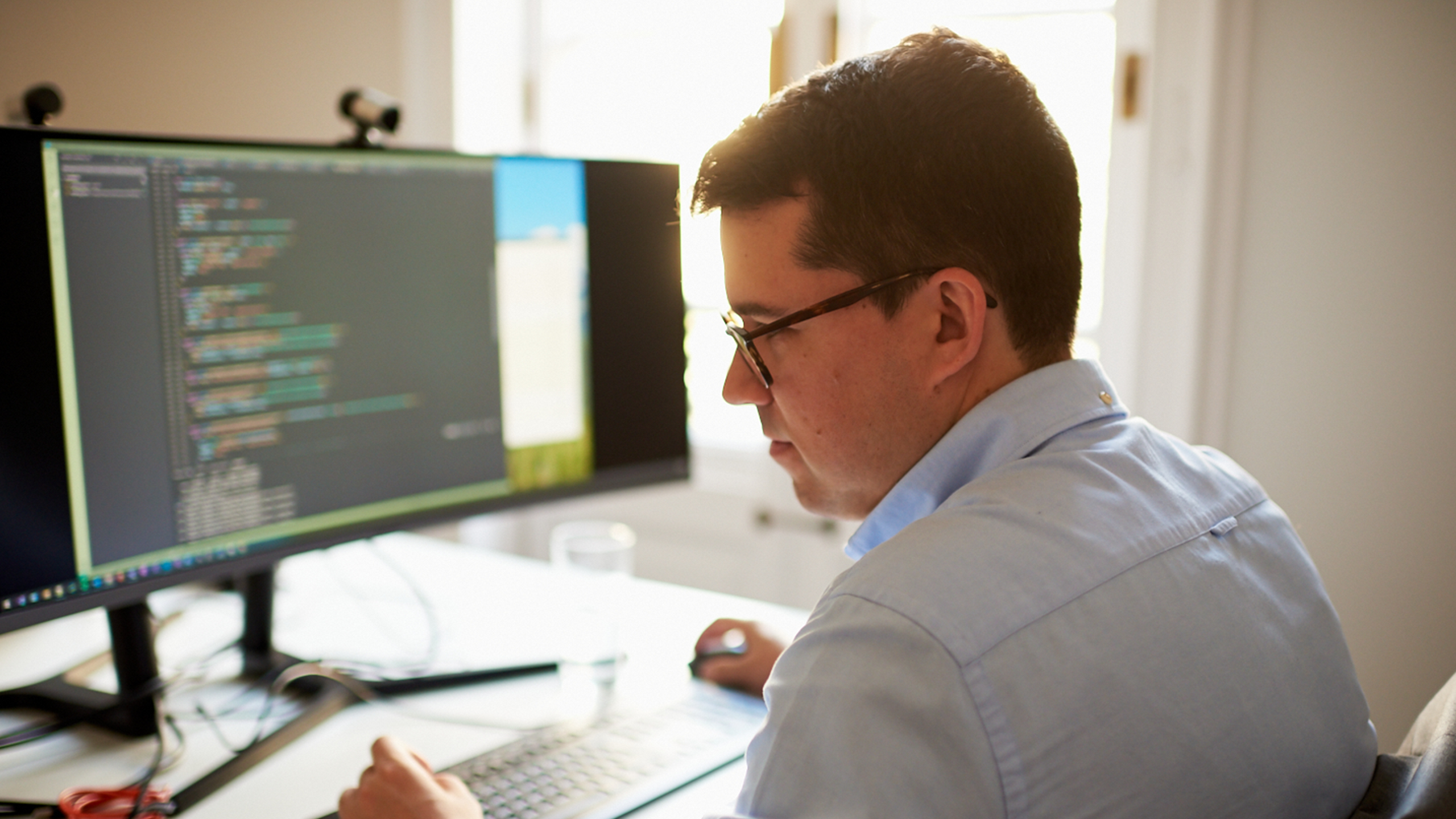 Software Architect in front of a screen with code