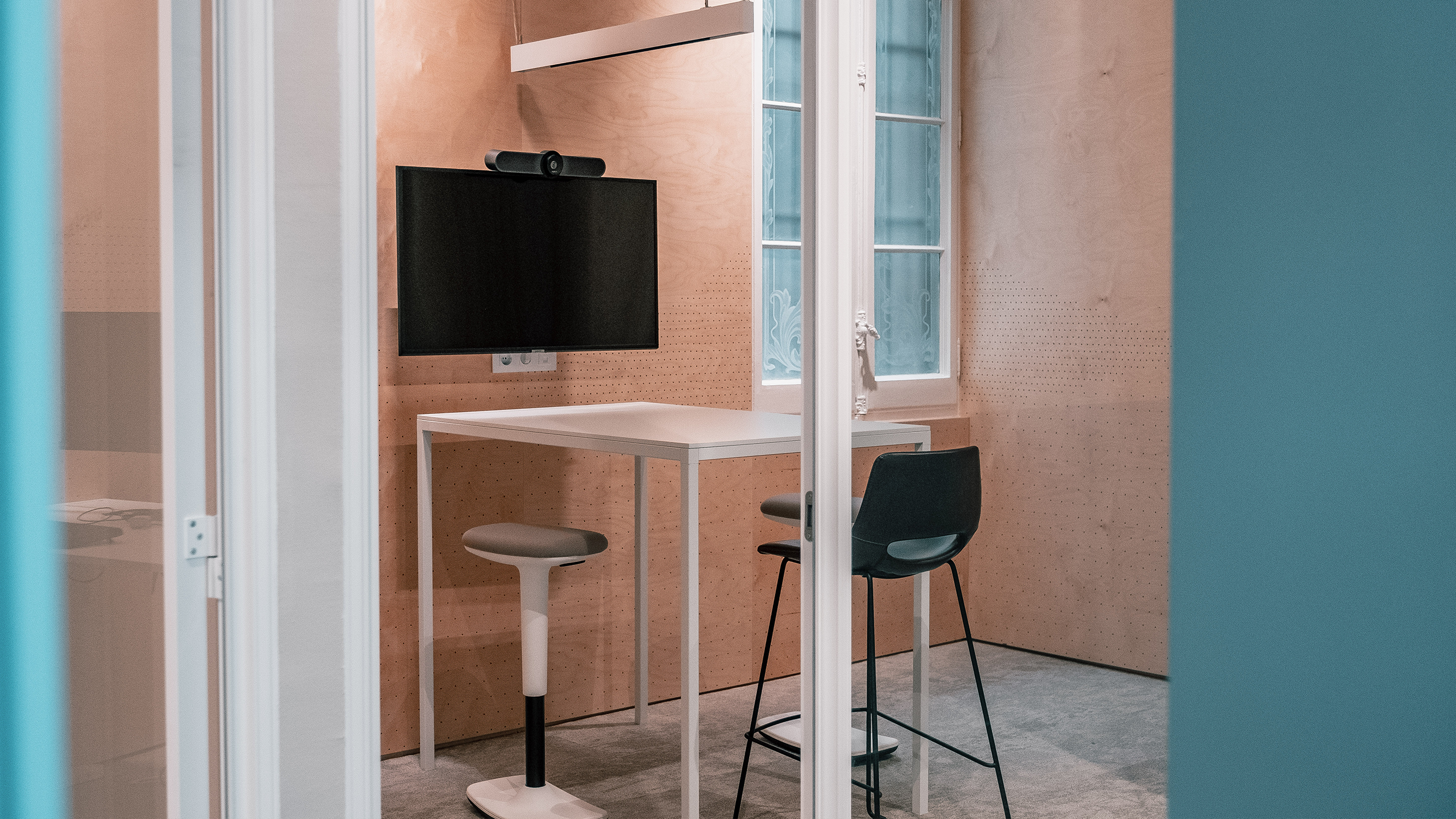 Meeting room with a standing desk and a big screen
