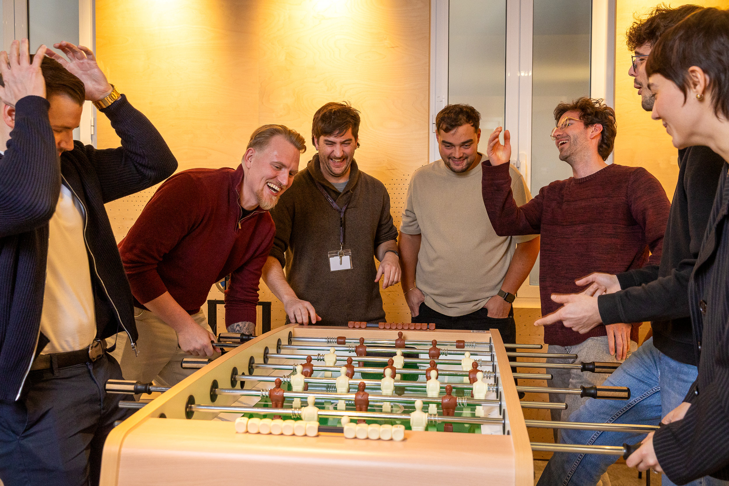 Team playing table football in office break area