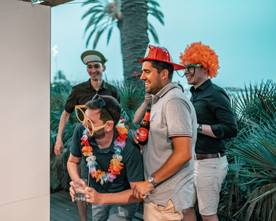 Group of people taking pictures with funny hats in front of a photo booth